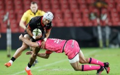 Lions wing Edwill van der Merwe (L) is tackled during a European Challenge Cup against Stade Francais in Johannesburg.
