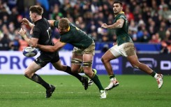 Springbok Pieter-Steph du Toit (C) tackles All Black Jordie Barrett during the 2023 Rugby World Cup final in Paris.