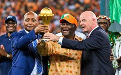 CAF president Patrice Motsepe (L), President Alassane Ouattara of the Ivory Coast and FIFA president Gianni Infantino hold the Africa Cup of Nations trophy after hosts Ivory Coast won the 2024 final.