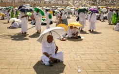 Muslim pilgrims use umbrellas to shade themselves from the sun as they arrive at the base of Mount Arafat during the hajj