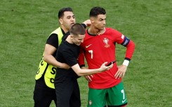 A pitch invader takes a selfie with Cristiano Ronaldo 