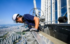 Seo Seung-ho looks down from a special gondola at the Lotte World Tower