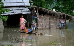 A family carries their belongings on a raft in India's flood-hit Assam state