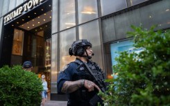 Law enforcement stand guard outside of Trump Tower in New York City after the rally shooting