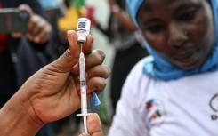 A nurse prepares a dose of a vaccine against malaria on the first day of a vaccination drive in Ivory Coast