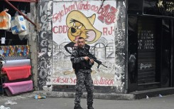 A Military Police officer patrols a street in the Cidade de Deus (City of God) favela inRio de Janeiro