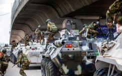 Bangladesh troops disembark armoured vehicles as they patrol the streets of the capital