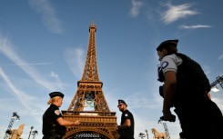 French police officers stand guard in front of the Eiffel Tower 