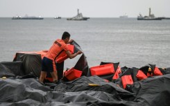 A coast guard staffer arranges an oil spill containment boom to be use3d in Manila Bay