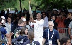 US rapper Snoop Dogg holds the torch as part of the 2024 Paris Olympics torch relay, on the day of the opening ceremony