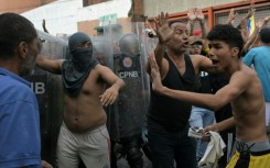 Demonstrators try to calm down among themselves as they clash with police officers during a protest against Venezuelan President Nicolas Maduro's government in Caracas on July 29, 2024