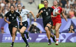 New Zealand's Sarah Hirini (2R) runs with the ball during the final victory over Canada