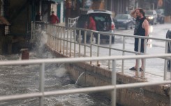 A rain-soaked man in Cedar Key, Florida observes waves kicked up by the winds of Tropical Storm Debby, which is strengthening as it moves through the Gulf of Mexico on August 04, 2024 