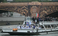 Chad's flag bearer Madaye Israel waves his country's flag (top right)at the Olympics opening ceremony in Paris