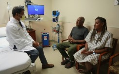 Doctor Satish Nadig (L), professor of surgery at the Northwestern University-Feinberg School of Medicine, speaks with patient, Harry Stackhouse (C), 74, and his daughter Trewaunda Stackhouse, 45, in a clinic post-transplant room at Northwestern Medicine 