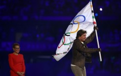 Tom Cruise takes the Olympic flag as Karen Bass, the mayor of 2028 hosts Los Angeles, looks on