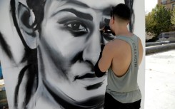 An artist paints a large portrait of Algerian Olympic boxing champion Imane Khelif in her hometown Tiaret