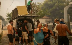 Residents cry as they try to save belongings from homes in Penteli, one of the Athens suburbs worst hit by a wildfire that forced the evacuation of thousands of people