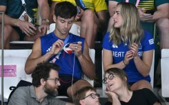 When he wasn't in the pool at the Olympics, Britain's Tom Daley (L) was spotted enjoying the Games from the stands while knitting