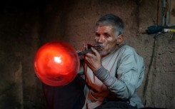 Afghan glassblower Ghulam Sakhi Saifi crafts glassware at his traditional workshop in the western city of Herat