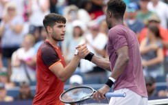 Spain's Carlos Alcaraz, left, shakes hands with Gael Monfils after falling to the Frenchman at the ATP and WTA Cincinnati Open