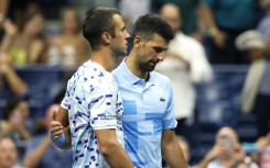 Painful end: Laslo Djere is consoled by  Novak Djokovic after being forced to retire from their second round match