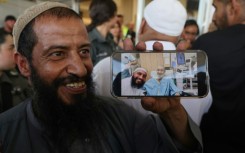 The brother of freed Israeli hostage Kaid Alkadi shows a mobile phone picture of him with another brother