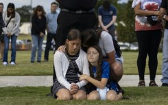 A mother and her children bow their heads in prayer at a vigil for the victims of the Apalachee High School shooting in Winder, Georgia