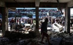 Palestinians survey the Al-Jawni school in central Gaza after an Israeli air strike 