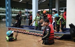 Local rescue teams pick up schoolchildren who were trapped overnight during flooding in the northern Thai city of Chiang Rai on September 12