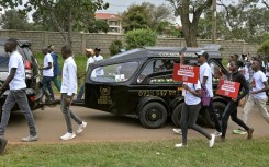 Anti-femicide marchers walk alongside a hearse carrying the body of murdered Olympian Rebecca Cheptegei in western Kenya