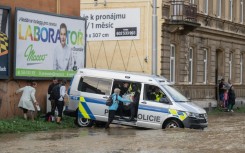 Police officers evacuate people at a flooded street in Opava, Czech Republic during storm Boris