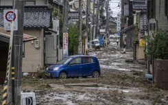 A stranded car is seen in a mud-covered road following heavy rain in Wajima city, Ishikawa prefecture