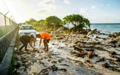 A photo taken on December 6, 2021 shows high-tide flooding and debris covering the road to the airport in the Marshall Islands capital Majuro