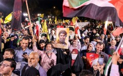 A crowd celebrated the Iranian strikes on Tuesday in Tehran, some of them holding posters of slaim Hezbollah leader Hassan Nasrallah 