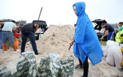 Residents fill sandbags as rain starts to fall in Kissimmee, Florida