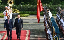 Vietnam Prime Minister Pham Minh Chinh (left) and China's Premier Li Qiang inspect a guard of honour during a welcoming ceremony at the Presidential Palace in Hanoi on October 13, 2024