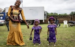 The twins paraded in immaculate matching outfits -- from glamorous sunglasses and patterned adire fabric to a pair of toddlers sporting purple dresses and identical handbags