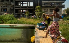 A woman uses a rope and a plastic container to get water from a pool at the Grande Hotel in Beira