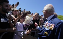 Britain's King Charles III chats with the owner of an alpaca named Hephner before leaving the Australian War Memorial in Canberra on October 21, 2024.