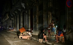 Cubans chat at night on a street during a nationwide blackout in Havana