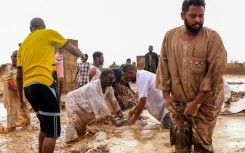 Men building a make-shift levee amid floods in Messawi, Sudan earlier this year