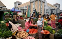 A vendor sells vegetables at a street market in Pyin Oo Lwin township, still in the hands of Myanmar's military