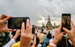 Spectators watch the Royal Barge Procession on the Chao Praya River