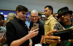 Apple CEO Tim Cook (C) is pushing the company into the AI era