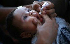 A medic administers a polio vaccine to a Palestinian child in Khan Yunis in the southern Gaza Strip 