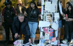 Geoff Payne (L), the father of One Direction pop singer Liam Payne, looks at a note placed by fans paying tribute to his late son outside the CasaSur Hotel in Buenos Aires on October 18, 2024