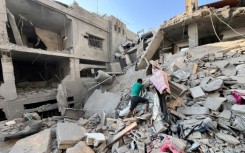 A Palestinian searches for relatives under rubble of building bombed by Israel in Beit Lahia