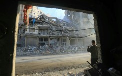 A man snaps a picture of a building hit by an Israeli strike, during a media tour organised by Hezbollah in Beirut's southern suburbs