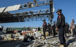 Firefighters, rescuers and passengers were working through abandoned luggage on the platform, guarded by heavily armed members of the security forces